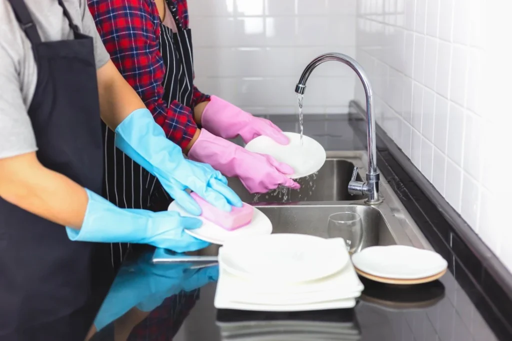Close up of 2 people doing the dishes
